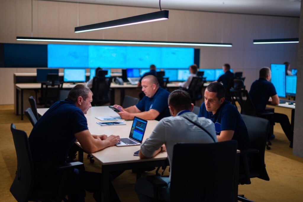 Group (security officers) tech guys meeting in a main security data center office.