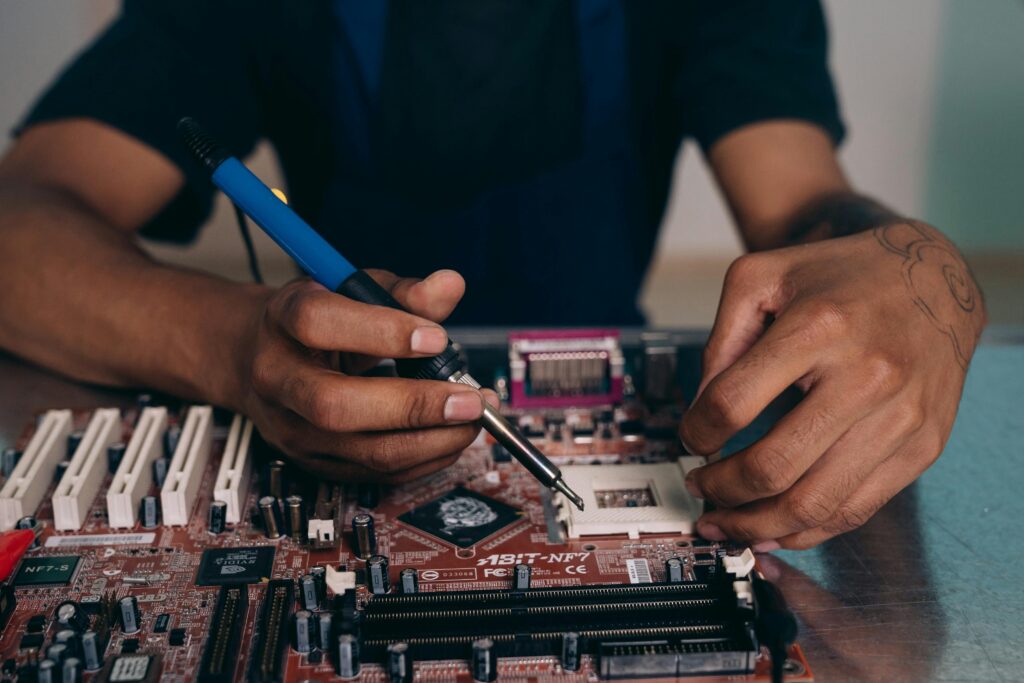 man using solder on motherboard